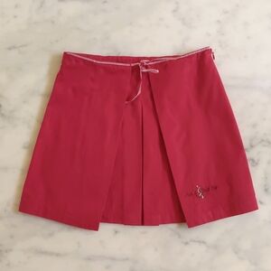 NWOT. 100% Cotton Red Pleated Skirt with Front Embroidered Logo & Left Side Zip.